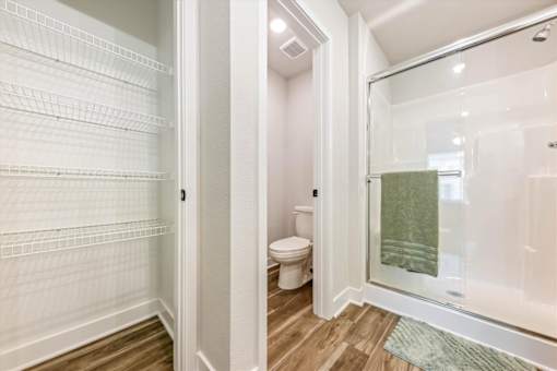 A white refrigerator is in a kitchen next to a bathroom.