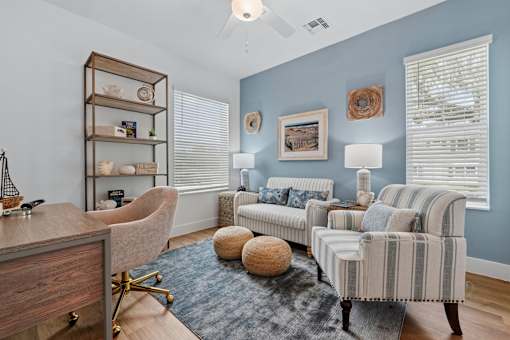 A living room with a blue wall and a striped sofa.