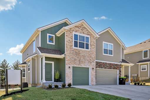 A modern two-story house with a garage and a driveway.