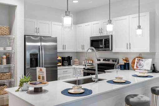 a kitchen with a large counter and a stainless steel refrigerator