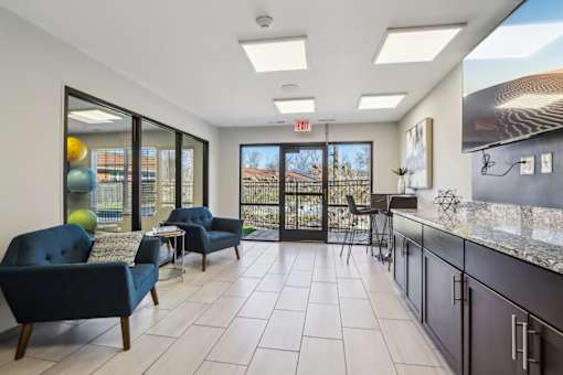 A spacious living room with a view of the outdoors through large windows.