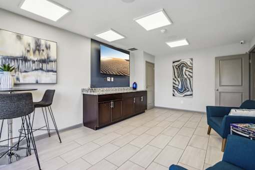 A living room with a bar area and a painting on the wall.