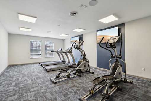 A gym with a row of stationary bikes.