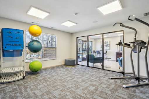 A gym with a blue wall and a yellow ball hanging from the ceiling.