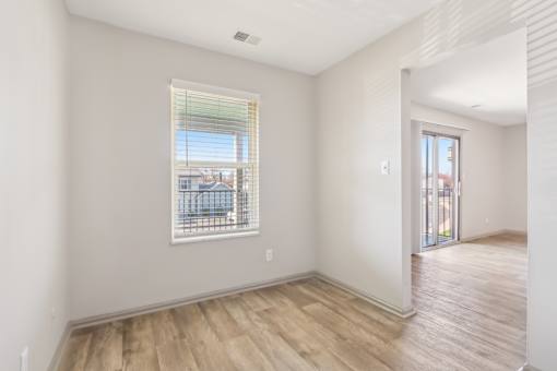 A room with a window and wooden flooring.