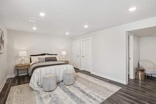 A bedroom with a large bed and a bench.