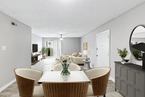 A dining room with a white table and brown chairs.