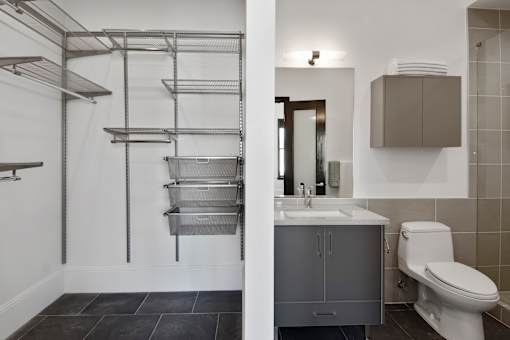 A bathroom with a white toilet and a grey cabinet.