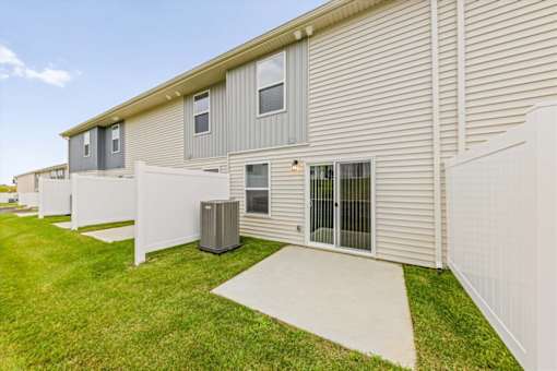 A white fence surrounds a building with a sliding glass door.