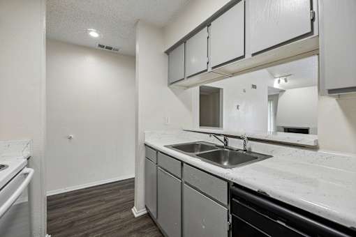 A kitchen with a sink and a stove top oven.