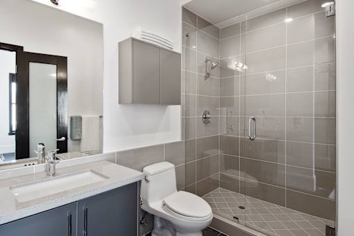 A modern bathroom with a toilet, sink, and shower.