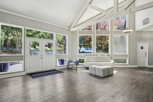 A spacious room with a white sofa and a wooden floor.