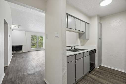 A kitchen with a sink, stove, and cabinets.