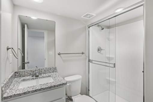 A bathroom with a sink, toilet, and shower.