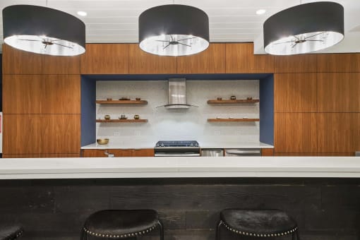 a kitchen with wood cabinets and a white counter top and black stools