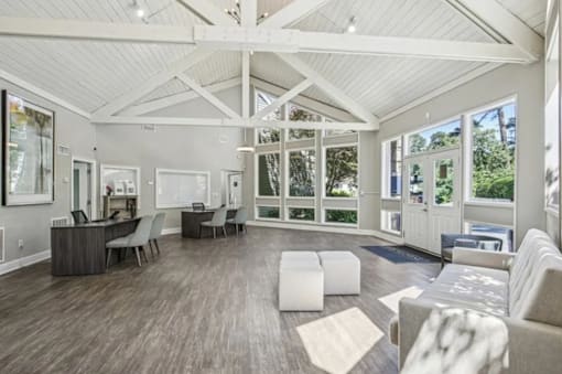 A spacious living room with a white ceiling and wooden flooring.