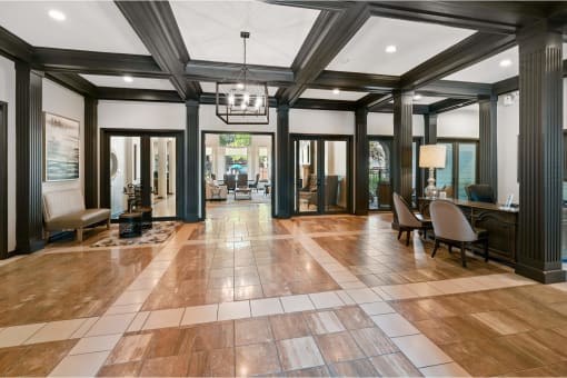a large lobby with chairs and a table and a chandelier