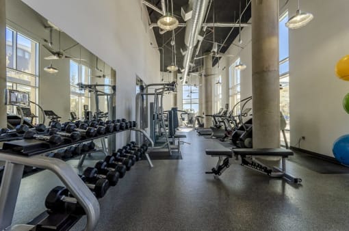 Fitness center with cardio equipment, strength training equipment, and free weights