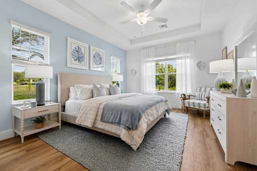 A bedroom with a large bed and a ceiling fan.