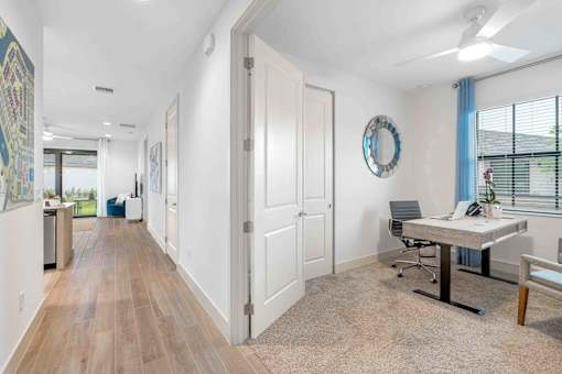 a white office with a desk and a mirror on the wall