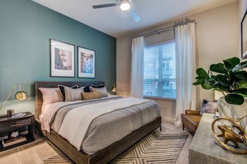 A bedroom with a large bed and a ceiling fan.