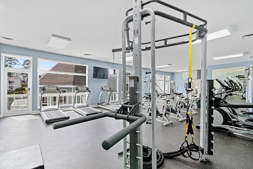 A gym with a treadmill, weights and exercise equipment.