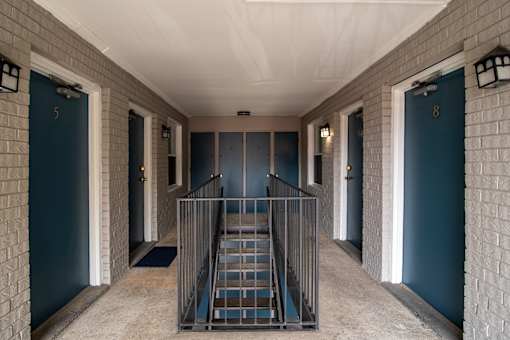 A staircase with a metal railing leads to a door with the number 8 on it.