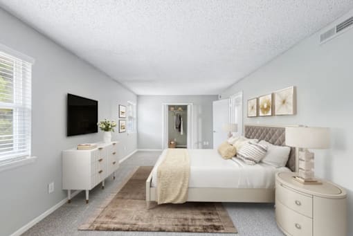 A bedroom with a bed, nightstand, and television.