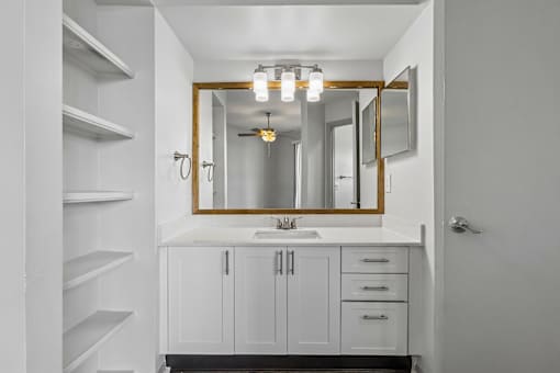 A bathroom with a white sink and a mirror above it.