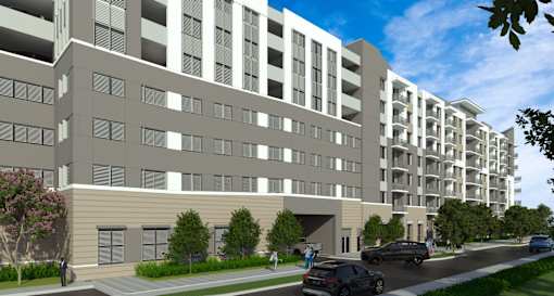 A modern apartment building with cars parked in front.