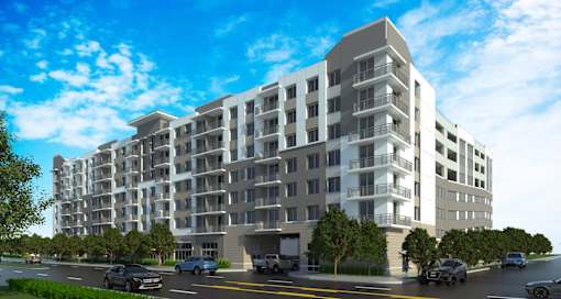 A modern apartment building with cars parked in front.