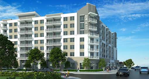 A modern apartment building with cars parked in front.