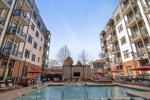 Apartments for Rent in
Germantown, Nashville, TN -
Peyton Stakes - Resort-Style Pool
with Submerged and Poolside
Lounge Seats, Hot Tub, Red
Umbrellas, and Surrounding
Apartment Buildings.
