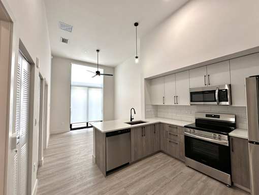 A modern kitchen with a large island and stainless steel appliances.