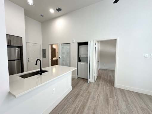 A kitchen with white countertops and a sink.