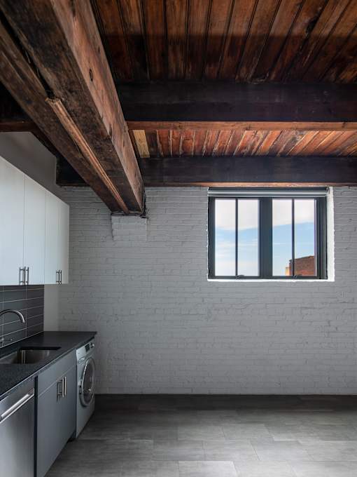 A kitchen with a window overlooking a building.