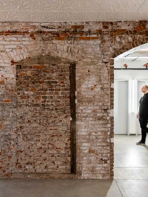 A man stands in a doorway between two rooms.