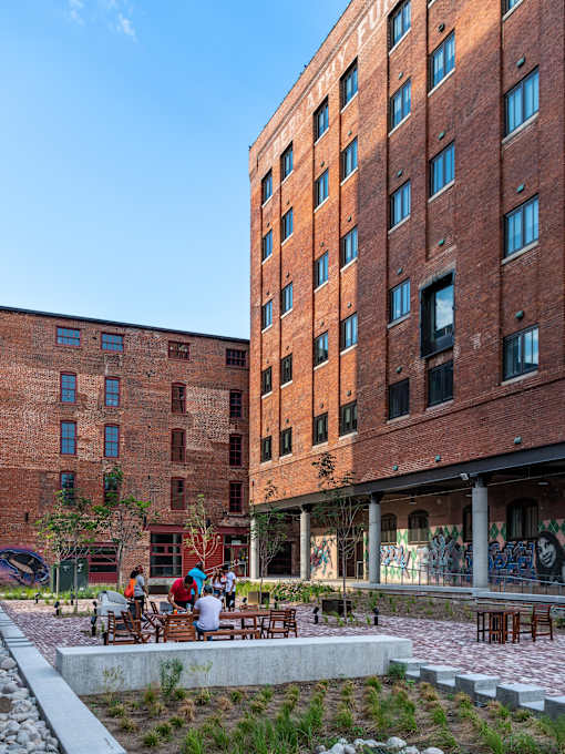 A red brick building with a courtyard in front.