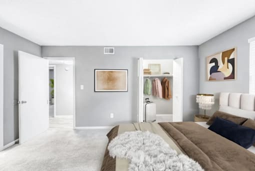 A bedroom with a large bed and a painting on the wall.