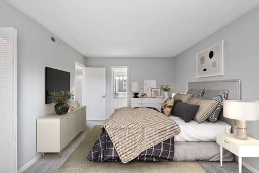 A bedroom with a bed, nightstand, and a television.