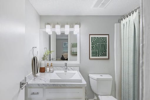 A bathroom with a white sink and toilet.