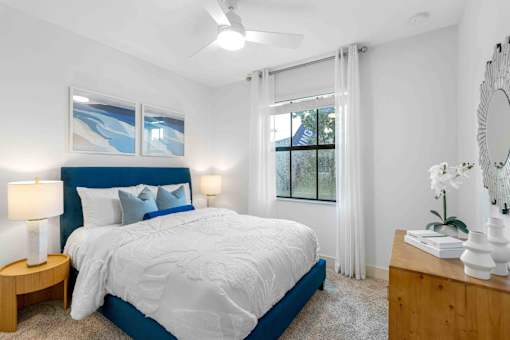 a bedroom with a blue and white bed and a window