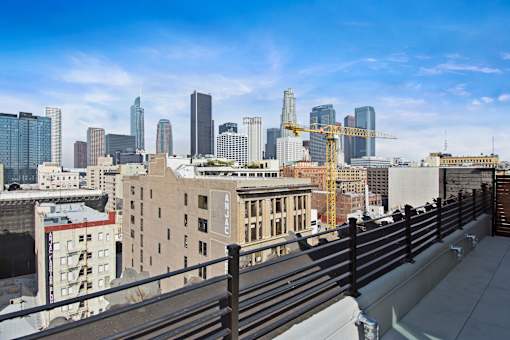 A cityscape with a clear blue sky and a construction site in the foreground.