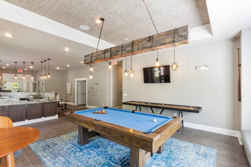 a games room with a pool table and a flat screen tv