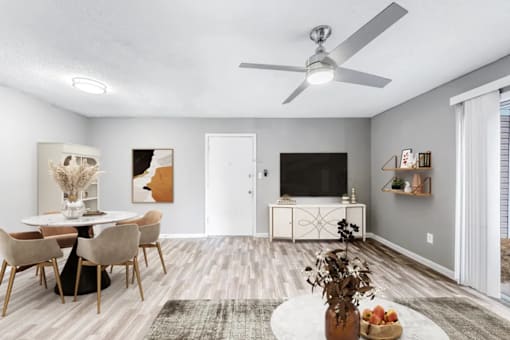 A living room with a white ceiling fan and a white table with chairs.