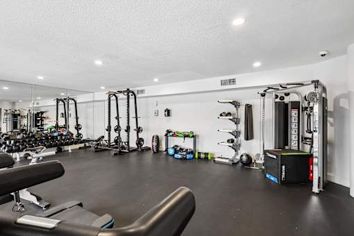A gym with a variety of equipment including weights and machines.