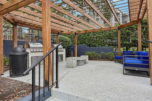 A wooden pergola with a metal railing and a concrete floor.