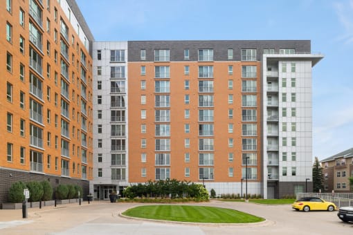 a large apartment building on a street with a parking lot at Verge Apartments in St. Louis Park, MN