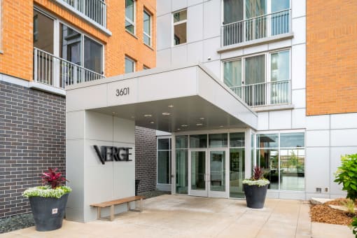 the front entrance of a building with the verge building name on it at Verge Apartments in St. Louis Park, MN
