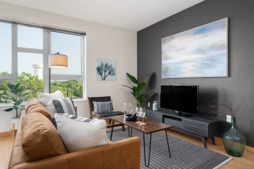 a living room with a couch and a television at Verge Apartments in St. Louis Park, MN